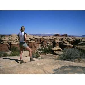  A Hiker Looks Out Over Canyonlands National Park Stretched 