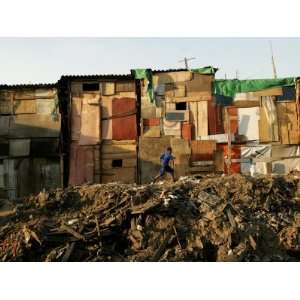  A Child Runs by a Row of Shacks in Novo Mundo Shantytown 